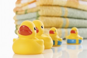 Rubber ducks and stack of colorful towels