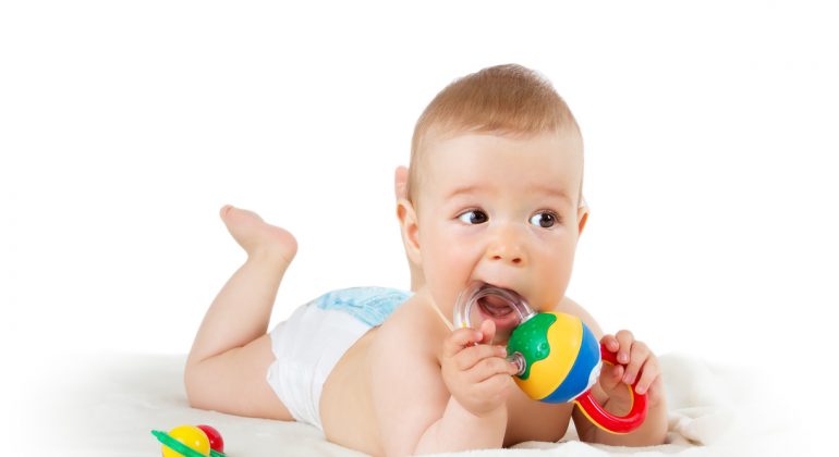 Baby holding a toy isolated on white background